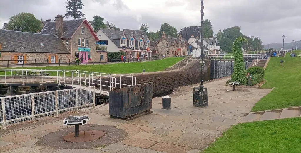 a bridge over a river in a town with houses at Fairvine Cabin Fort Augustus Mtn View Pet Friendly in Fort Augustus