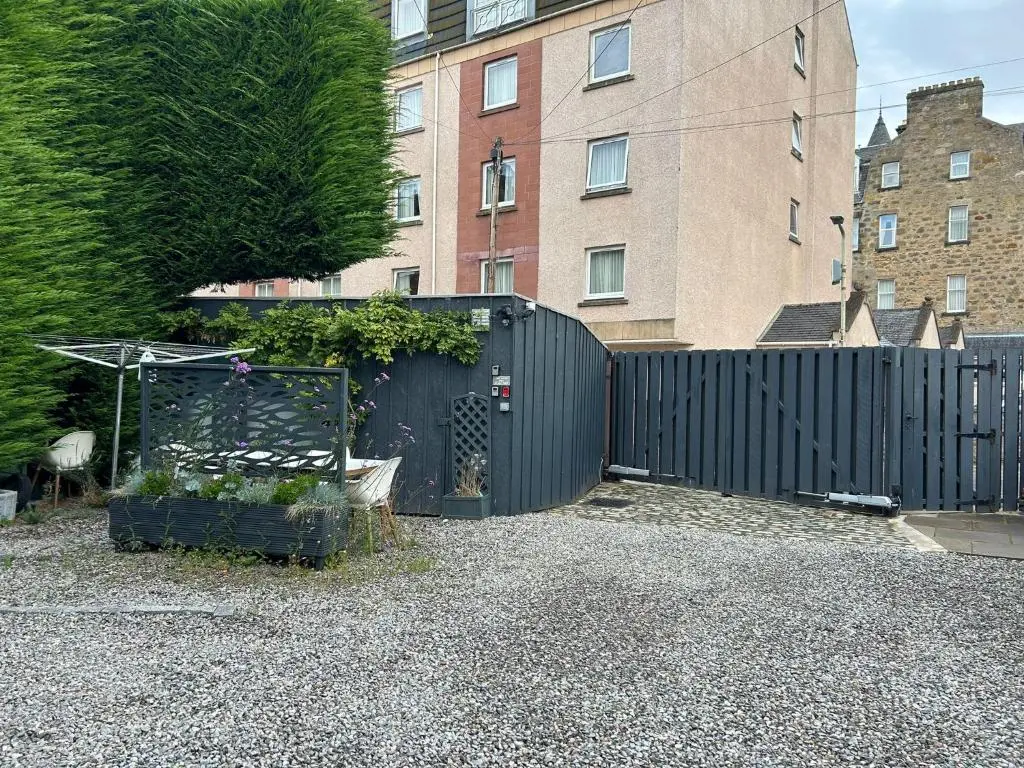 a black fence in a yard with a building at 1 Bedroom Alexander Snug-Free Parking in Inverness