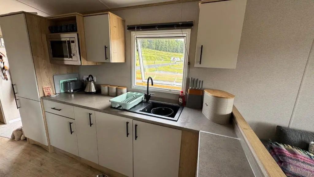 a small kitchen with a sink and a window at Wildcat Lodge Grantown on Spey in Grantown on Spey