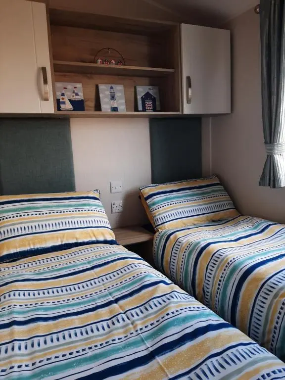 two beds sitting next to each other in a room at Swallows at Silversands in Lossiemouth