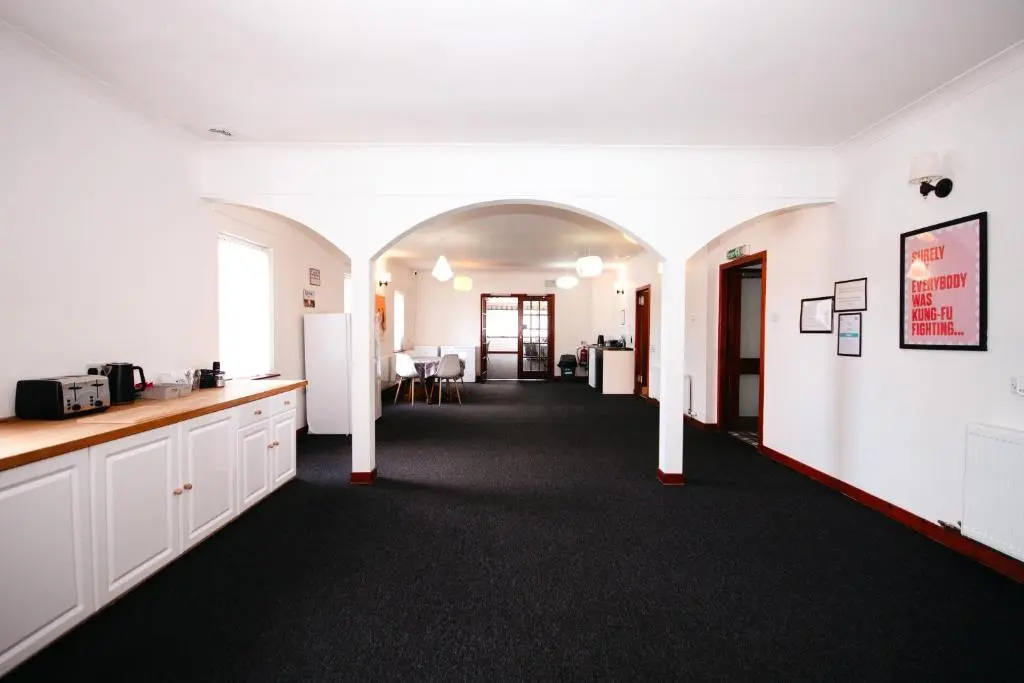 a room with white walls and a hallway with a kitchen at Weston House in Keith