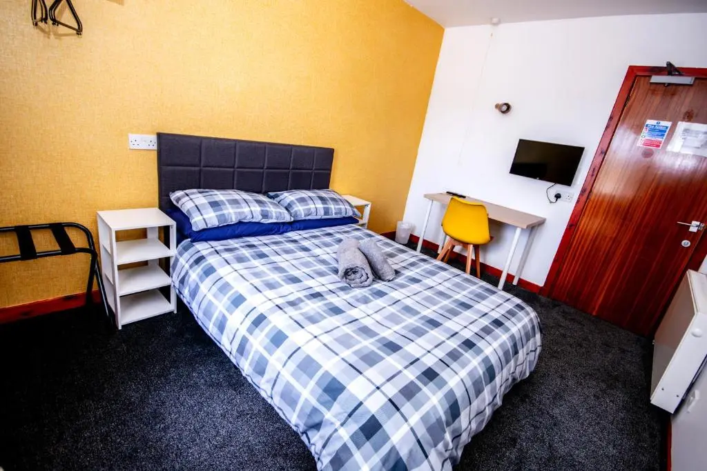a cat laying on a bed in a bedroom at Weston House in Keith