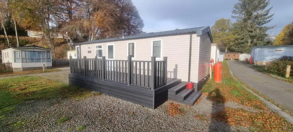 a mobile home with a porch and a fence at swift LOIRE in Evanton