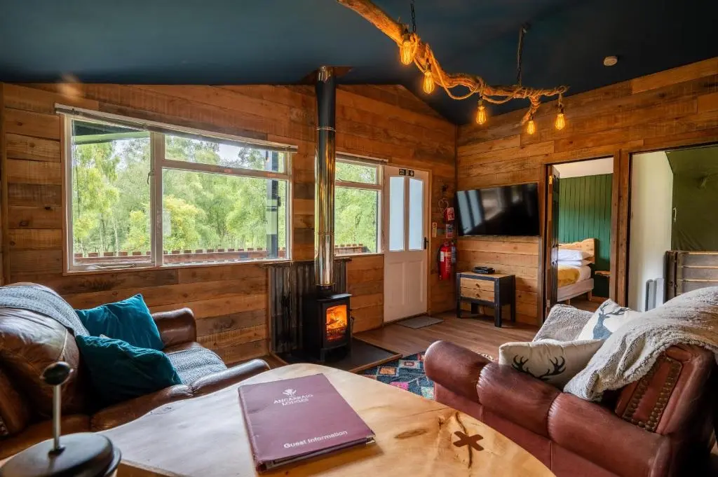 a living room with a couch and a table at Ancarraig Lodges in Drumnadrochit