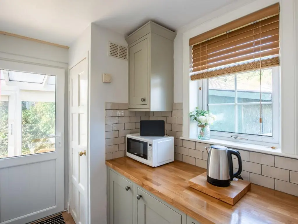 a kitchen with a counter with a microwave and a window at Holiday Home Jenkins Cottage by Interhome in Fort Augustus