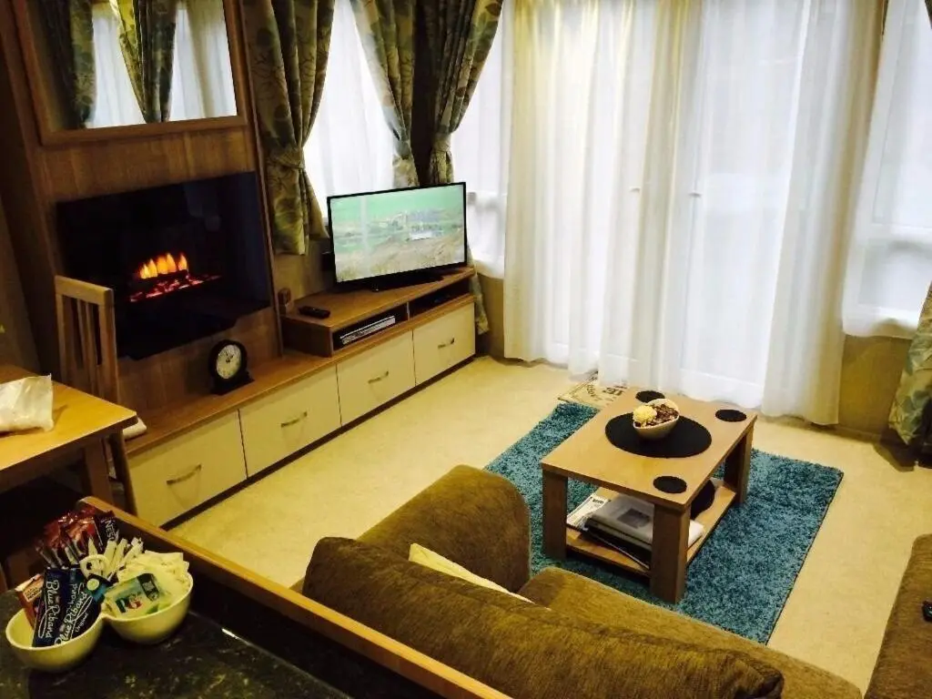 a living room with a couch and a tv at Aviemore holiday park No 39 in Aviemore