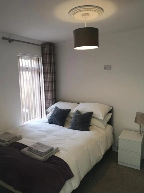 a bedroom with a large bed with a window at Friars Shott Cottage in Inverness