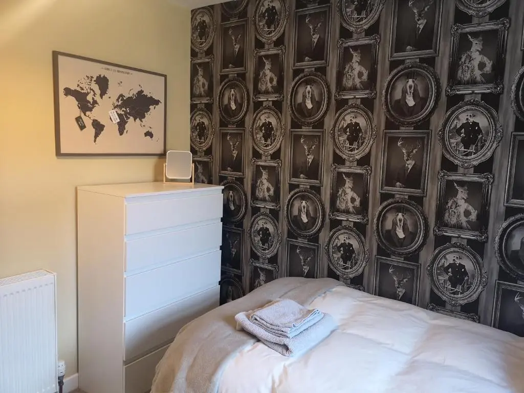 a bedroom with a black and white wall with plates at Friars Shott Cottage in Inverness