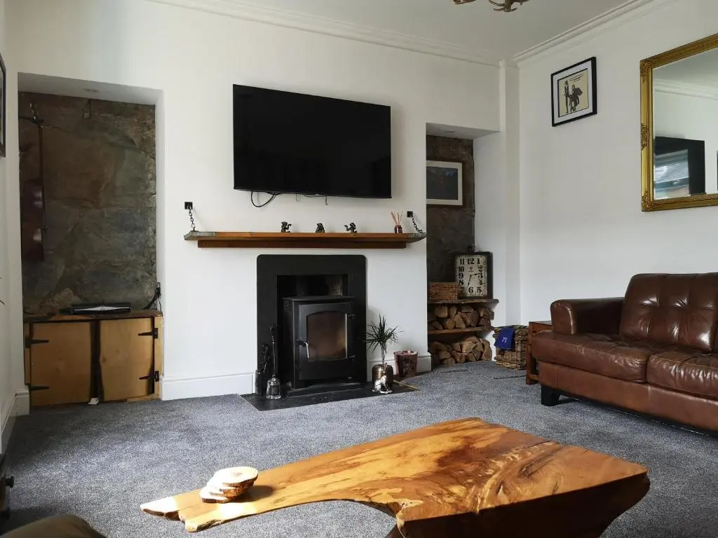 a living room with a couch and a fireplace at Friars Shott Cottage in Inverness