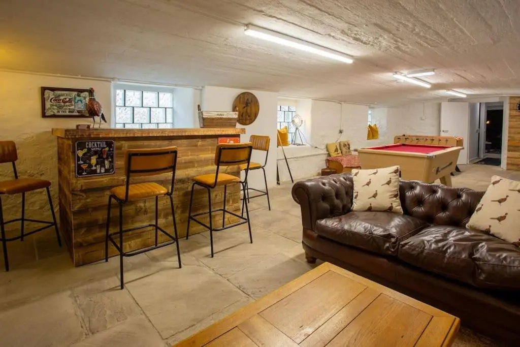 a living room with a couch and a bar at The Urquhart in Oldmeldrum
