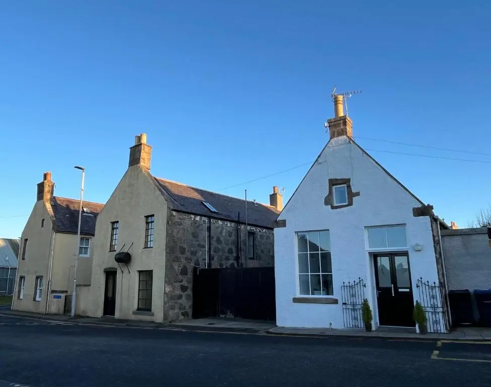 an old stone house on the side of a street at The Urquhart in Oldmeldrum