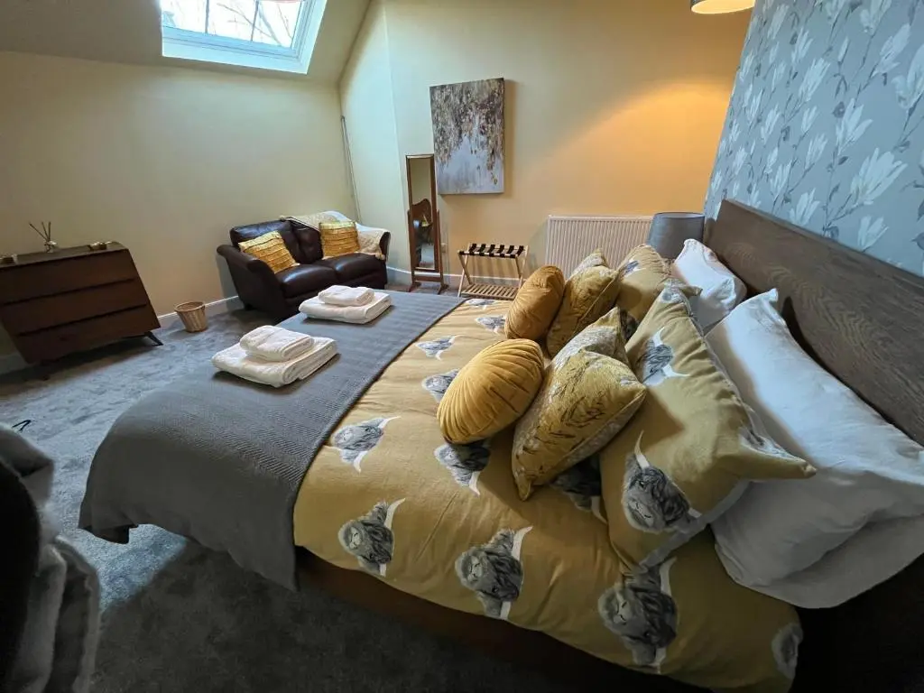 a bedroom with a large bed with pillows on it at The Urquhart in Oldmeldrum