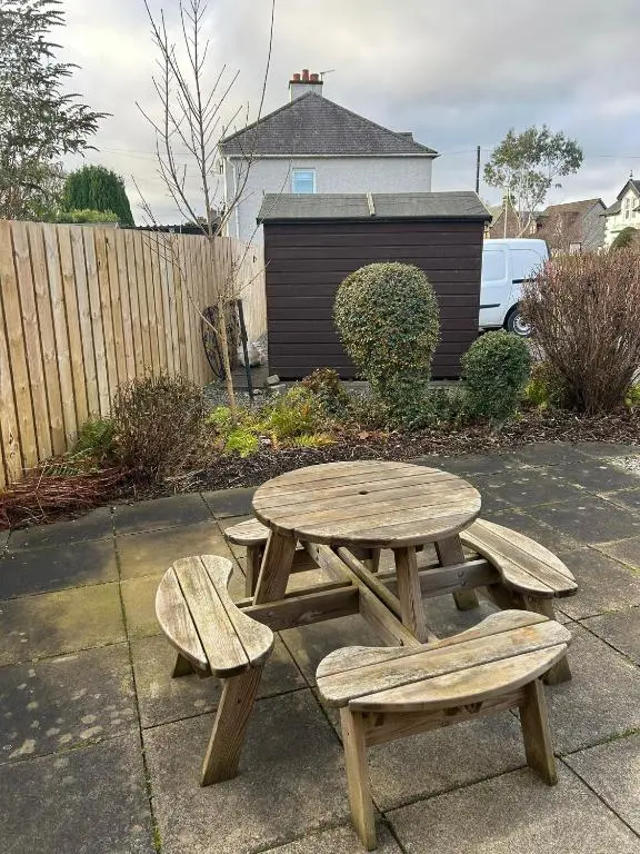 a picnic table and two benches on a sidewalk at 2 Bedroom Sheneval House Free Parking in Inverness
