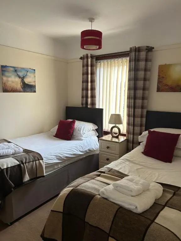 a bedroom with two beds and a window at 2 Bedroom Sheneval House Free Parking in Inverness