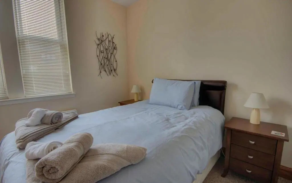 a bedroom with a bed with towels on it at 1 Argyle Place, Dornoch in Dornoch