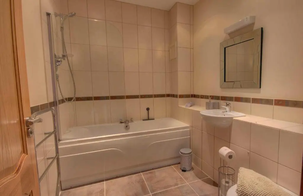 a bathroom with a tub and a sink at 1 Argyle Place, Dornoch in Dornoch