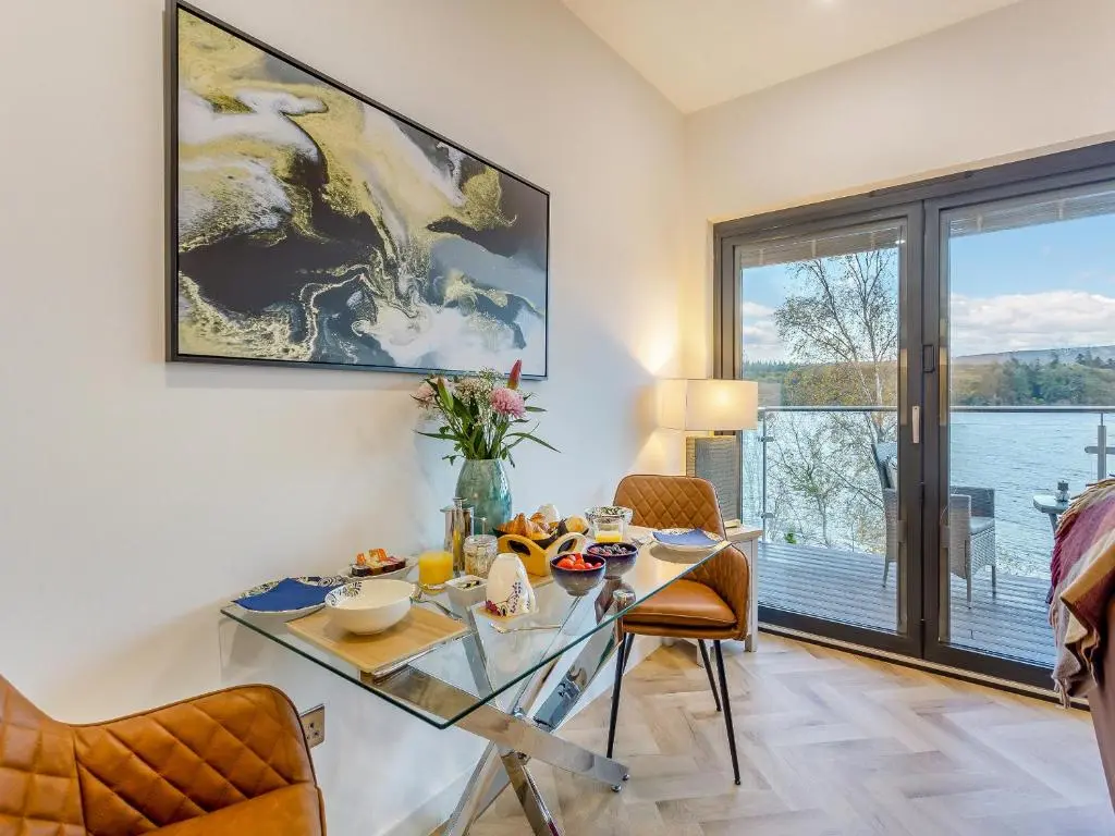 a dining room with a table and chairs and a window at Kimcraigan Lodge in Lochend