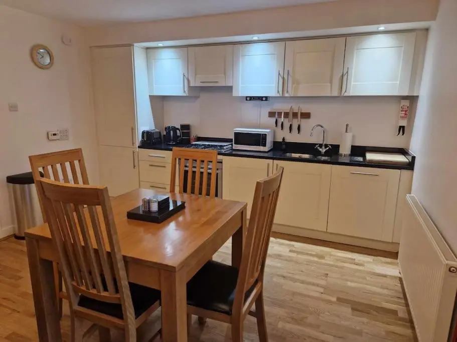 a kitchen with a wooden table and chairs and a counter at Glen Mor in Fort Augustus