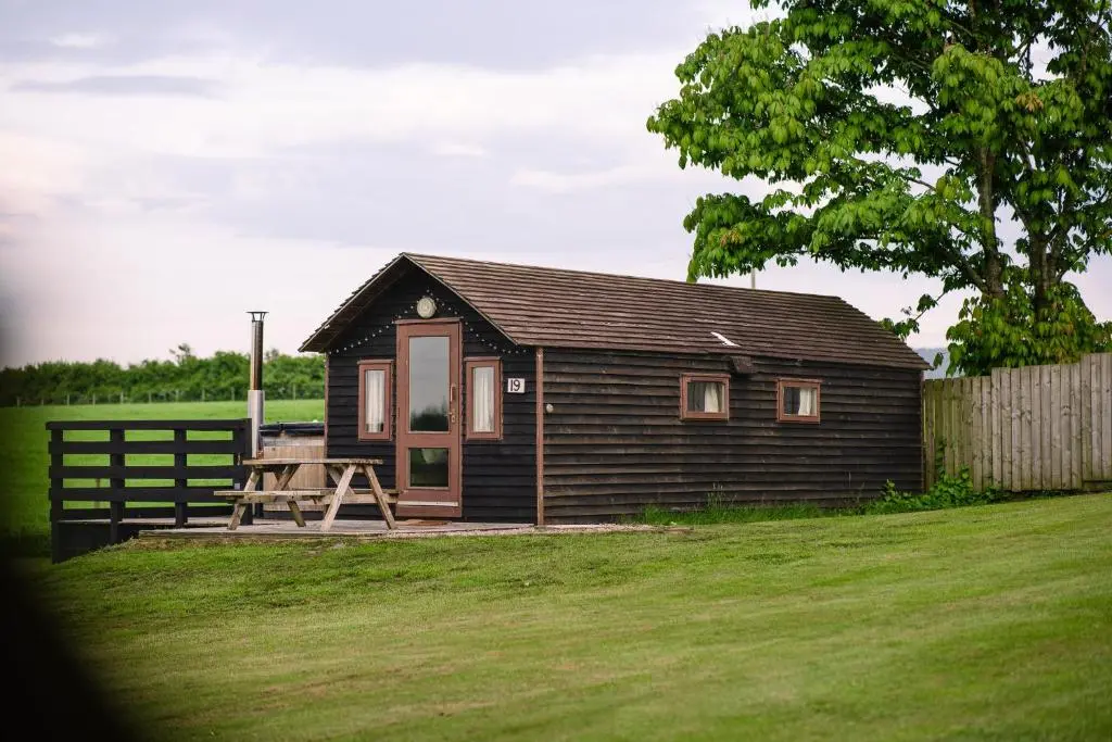 a small house in a yard with a fence at The Loft by Wigwam Holidays in Kinloss