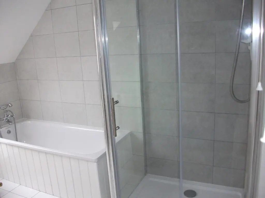a bathroom with a shower with a tub and a toilet at The Granary in Buckie