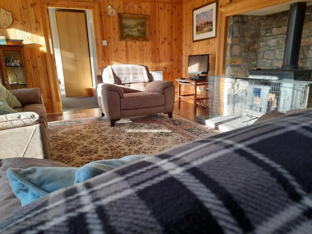 a living room with a couch and a stone fireplace at The Granary in Buckie