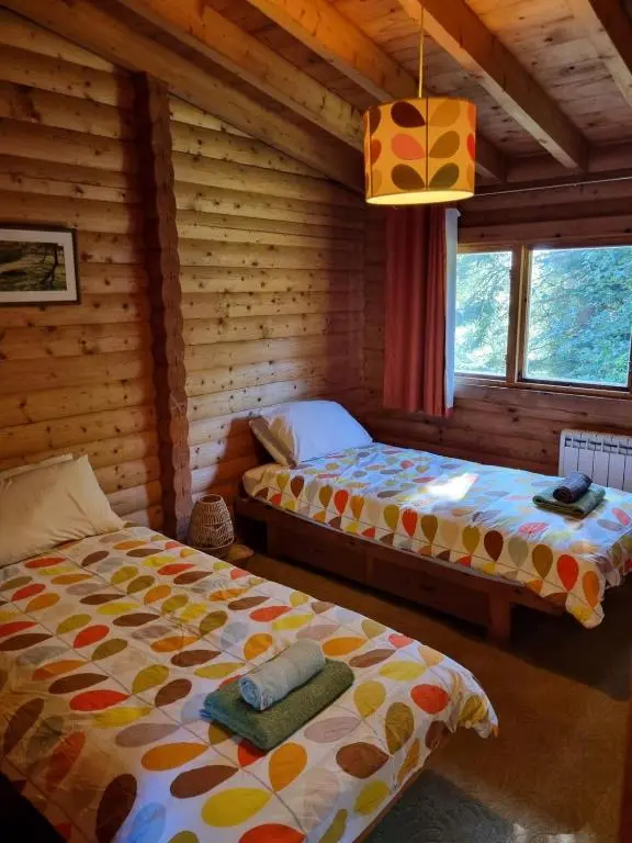 a bedroom with two beds in a log cabin at Our Log House in the woods in Balnald