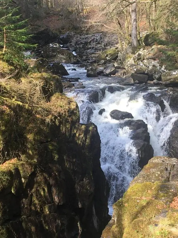 a stream of water rushing down a rocky river at Our Log House in the woods in Balnald