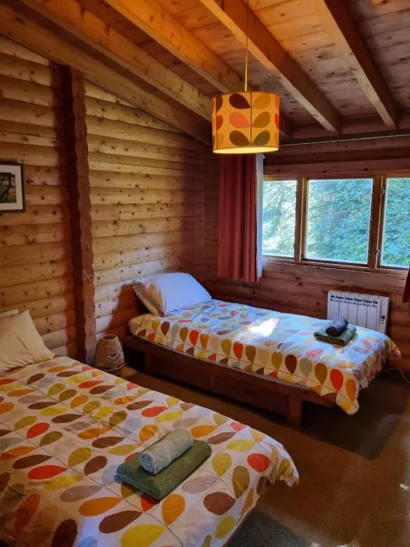 a bedroom with two beds in a log cabin at Our Log House in the woods in Balnald