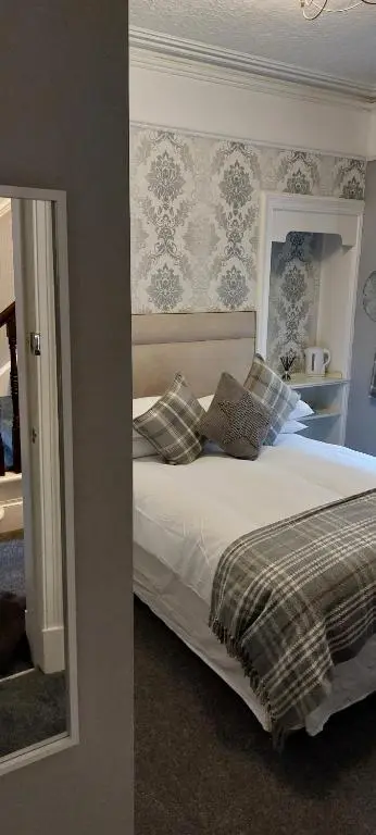 a bedroom with a bed and a mirror at Riverbank Guesthouse Inverness in Inverness