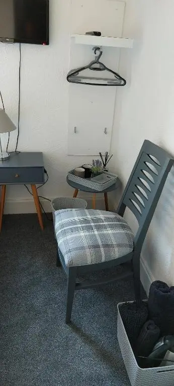 a room with a chair and a table and a tv at Riverbank Guesthouse Inverness in Inverness
