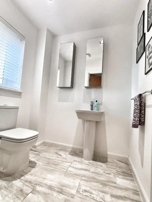 a bathroom with a toilet and a sink and mirrors at 4 miles to Westhill by Lains Lettings in Aberdeen