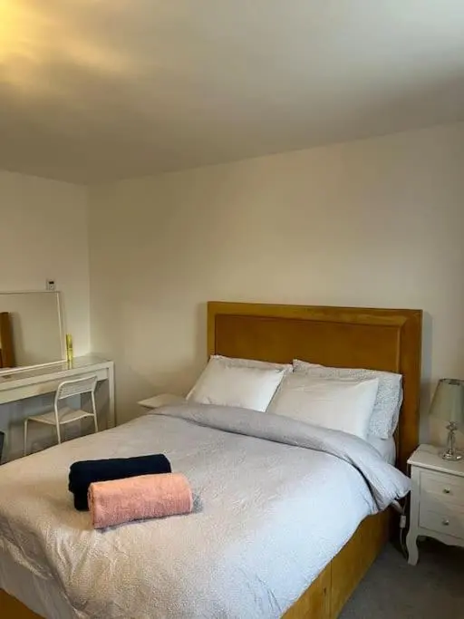 a bedroom with a bed with a pink towel on it at Lovely 2 bedroom home, free parking, 6 mins from airport in Bankhead