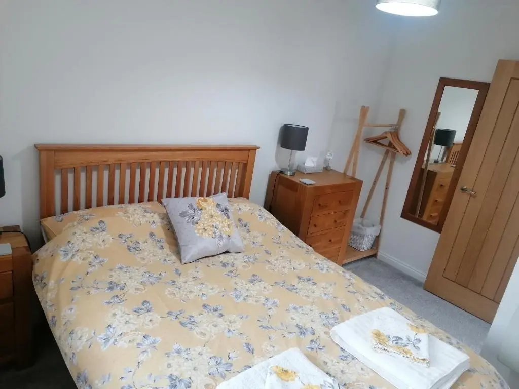 a bedroom with a bed and a dresser and a mirror at House in Alness in Alness