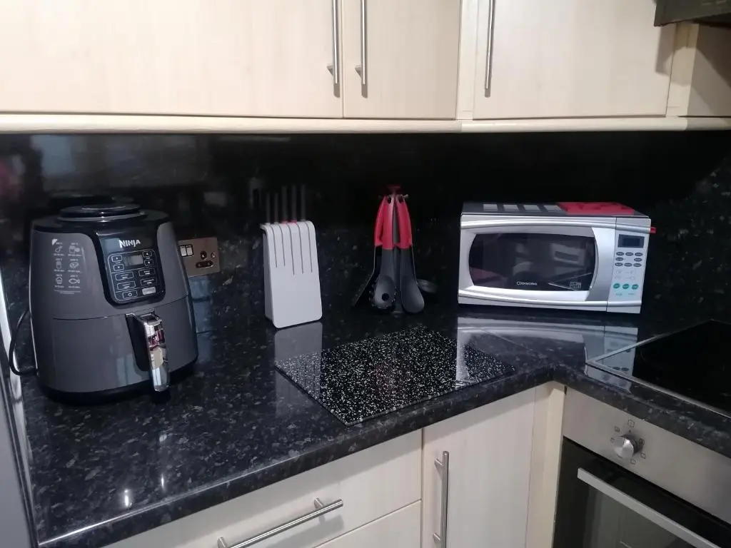 a kitchen counter with a toaster oven and a microwave at House in Alness in Alness