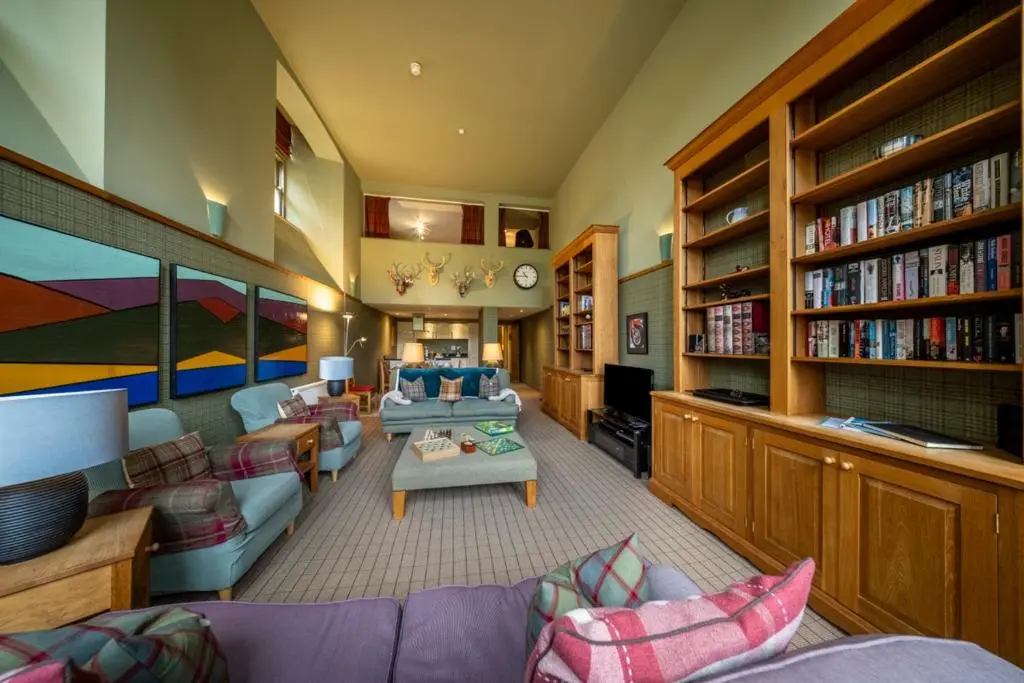 a large living room with a couch and a table at Old School Refectory Highland Club in Fort Augustus