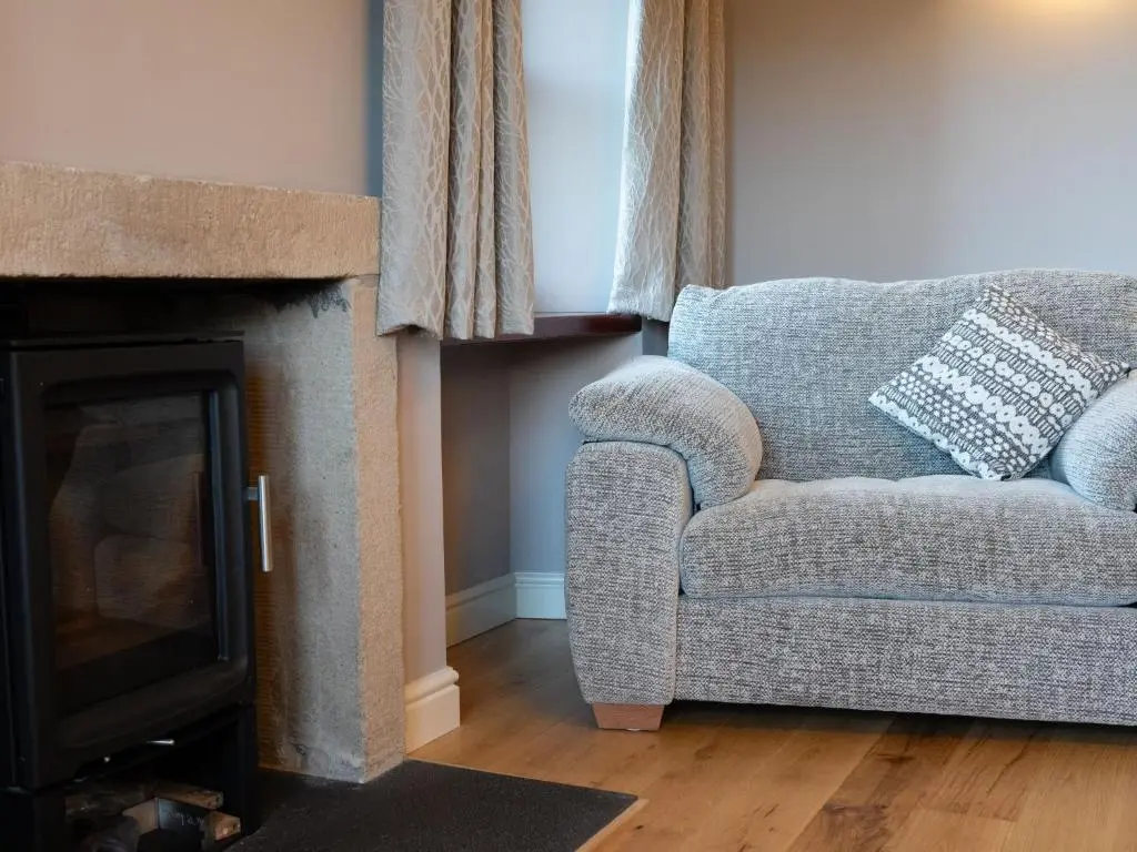 a living room with a couch and a fireplace at Holiday Home Rose Cottage by Interhome in Farr