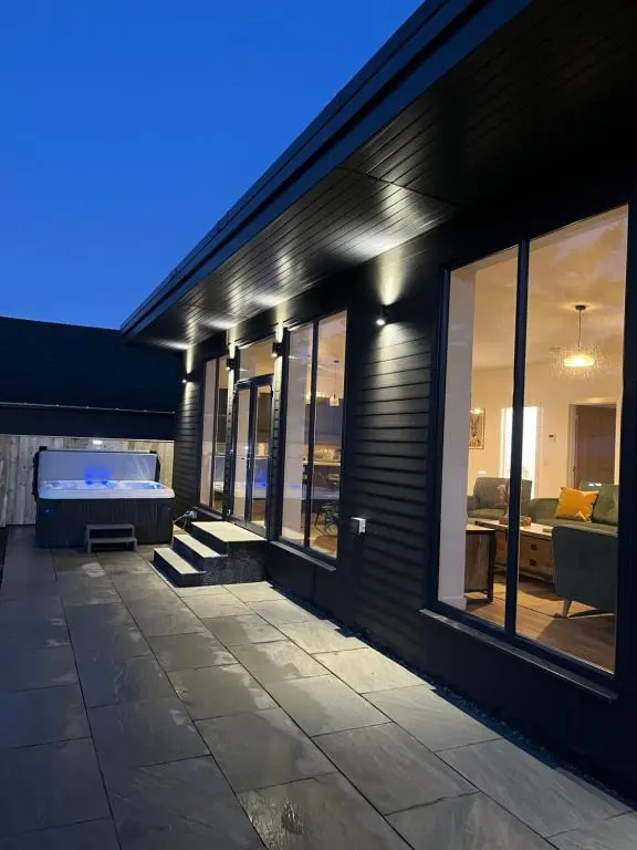 a house with a swimming pool in the side of it at Thrumster Lodges - 3 Luxurious Self Catering Lodges on the NC500, 2 with Hot Tubs in Wick
