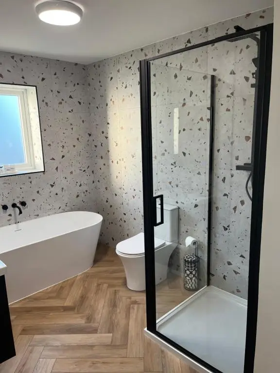 a bathroom with a bath tub and a toilet at Thrumster Lodges - 3 Luxurious Self Catering Lodges on the NC500, 2 with Hot Tubs in Wick