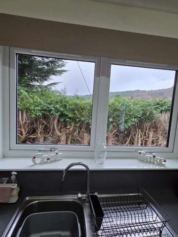 two windows above a kitchen sink with a view at Ardgay in Fort Augustus
