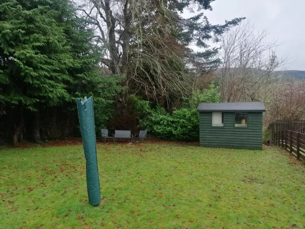 a green pole in a yard with a small shed at Ardgay in Fort Augustus