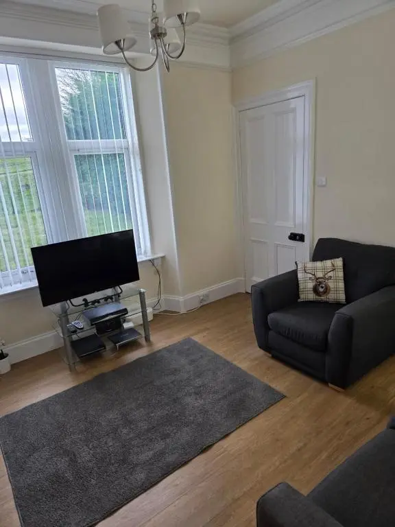 a living room with a couch and a flat screen tv at Ardgay in Fort Augustus