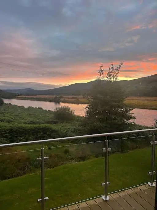 a view of a river from a balcony at Kerrow Burn Lodge Cannich Inverness-shire in Invercannich