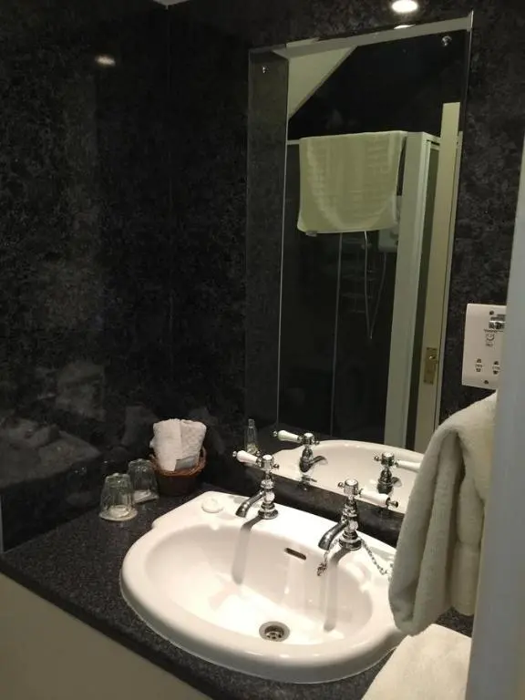 a bathroom with a white sink and a mirror at Roseneath Guest House in Inverness