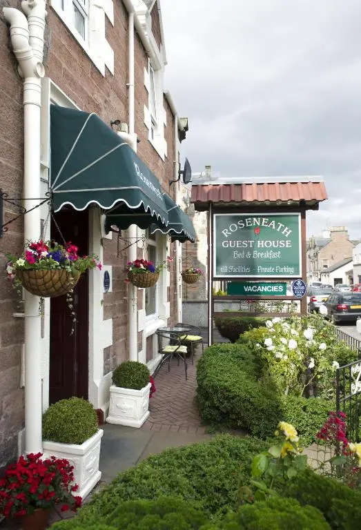 a building with flower baskets on the side of it at Roseneath Guest House in Inverness