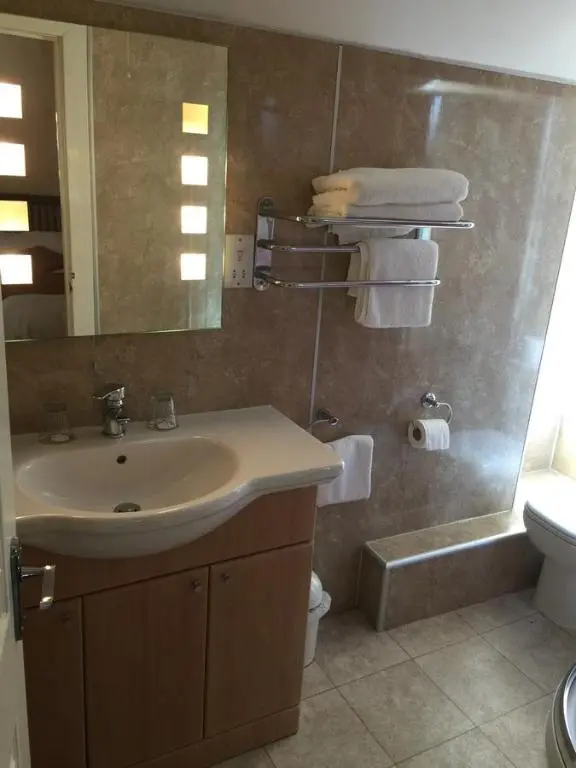 a bathroom with a sink and a toilet and a mirror at Roseneath Guest House in Inverness