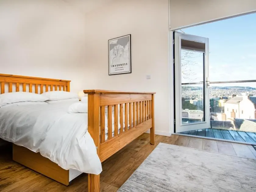 a bedroom with a bed and a large window at View Apartment in Inverness