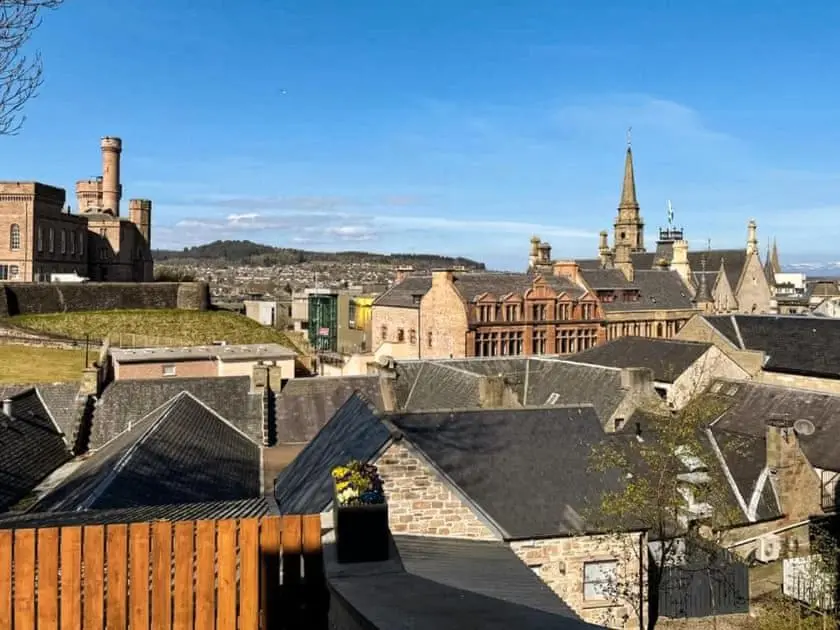 a view of a city with buildings and roofs at View Apartment in Inverness