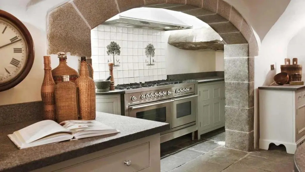 a kitchen with a clock and a book on a counter at Forter Castle in Blairgowrie