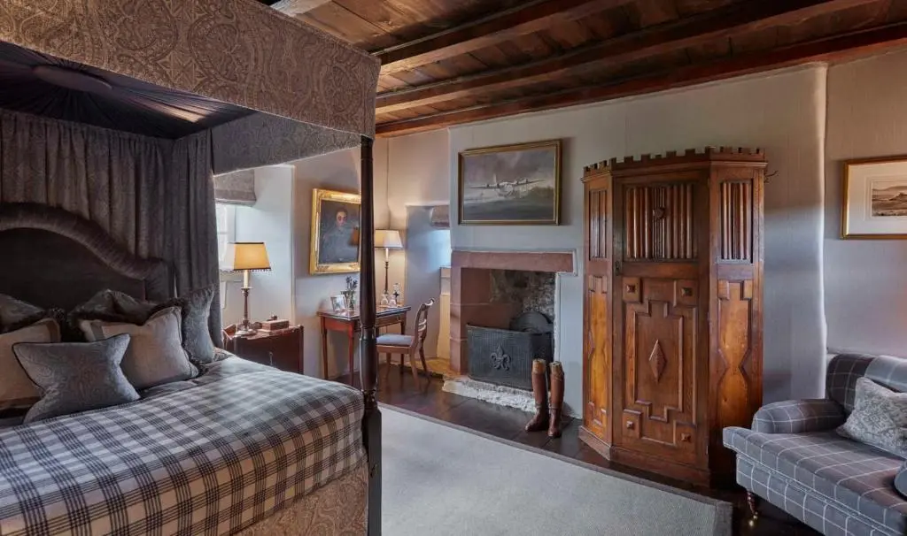 a bedroom with a bed and a fireplace at Forter Castle in Blairgowrie