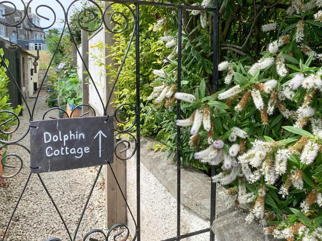 a gate with a sign that reads dahlium college at Dolphin Cottage in Nairn
